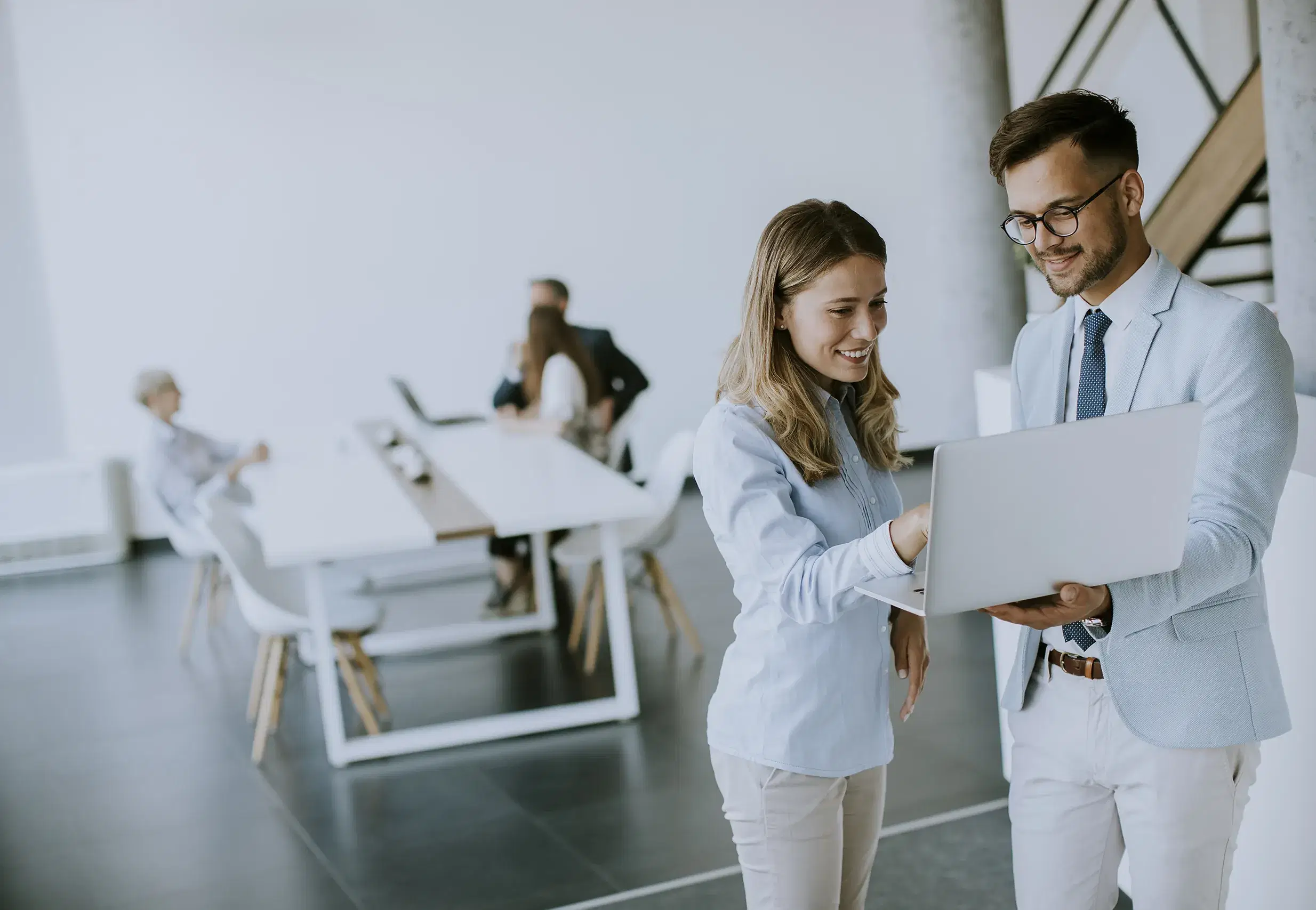 young-business-couple-working-discussing-by-laptop-office-front-their-team copy